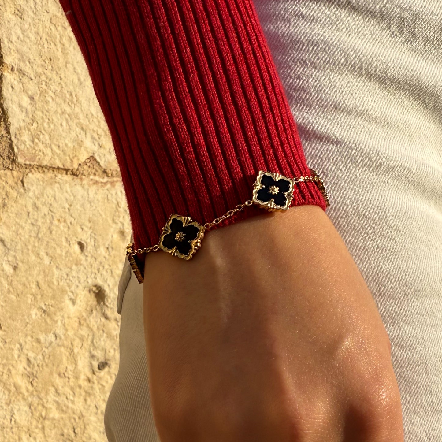 Bracelet en acier inoxydable avec des fleurs noires et dorées.