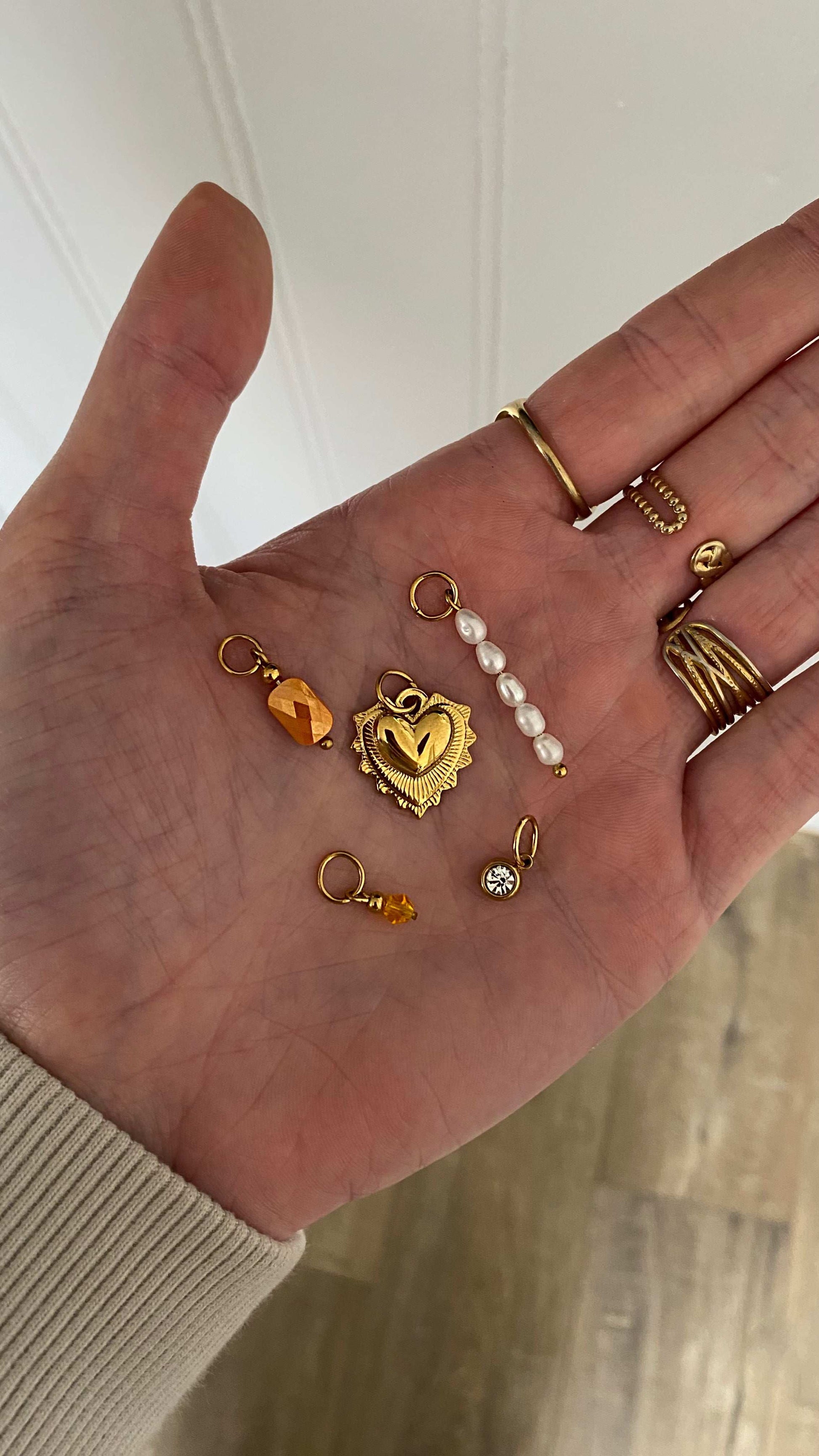 Plusieurs pendentifs dans une main.